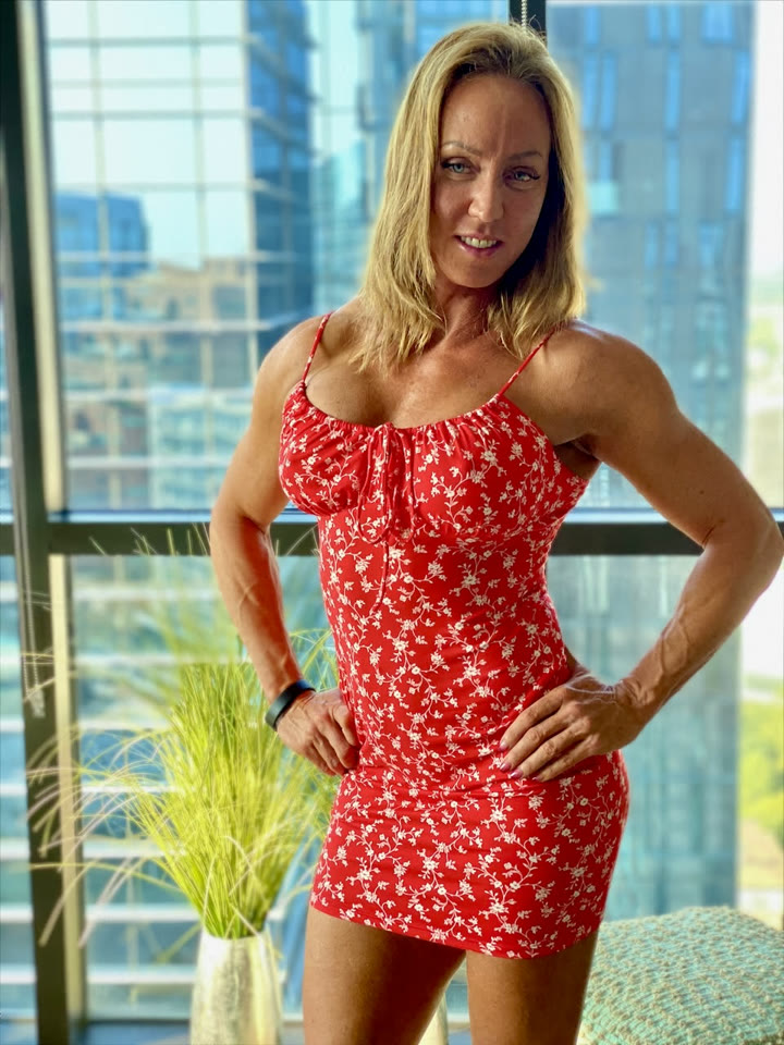 Jewels in a red floral dress by a city window